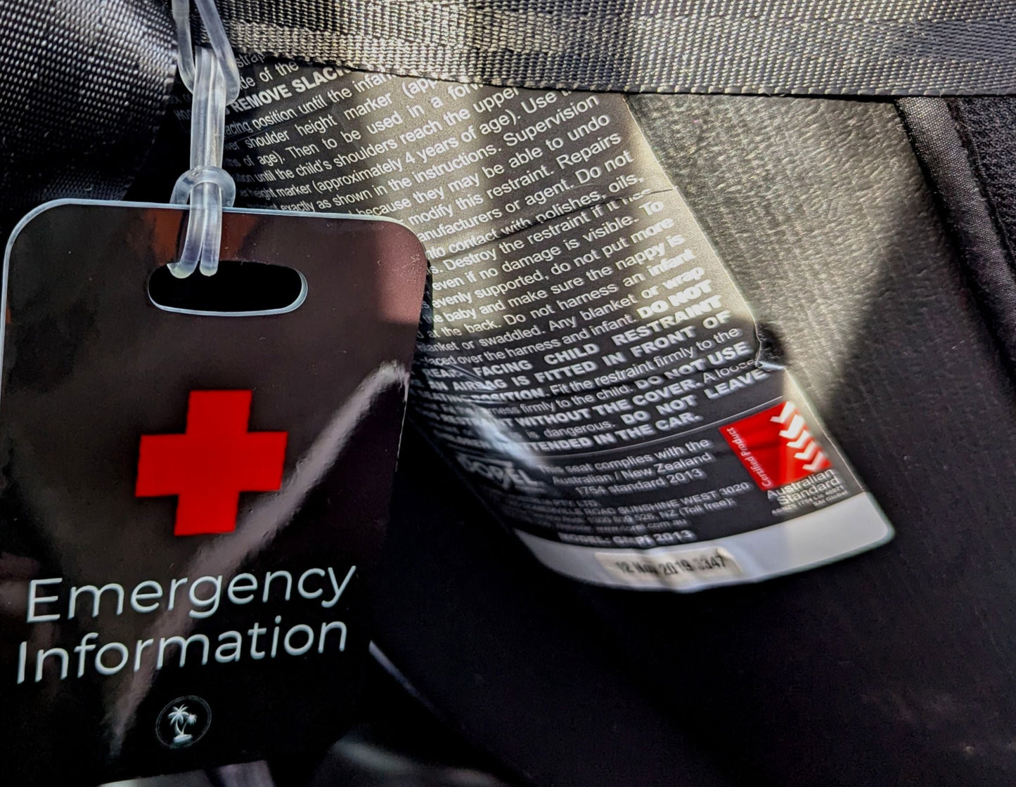 Black Emergency Medical Information Tag securely attached to child car seat