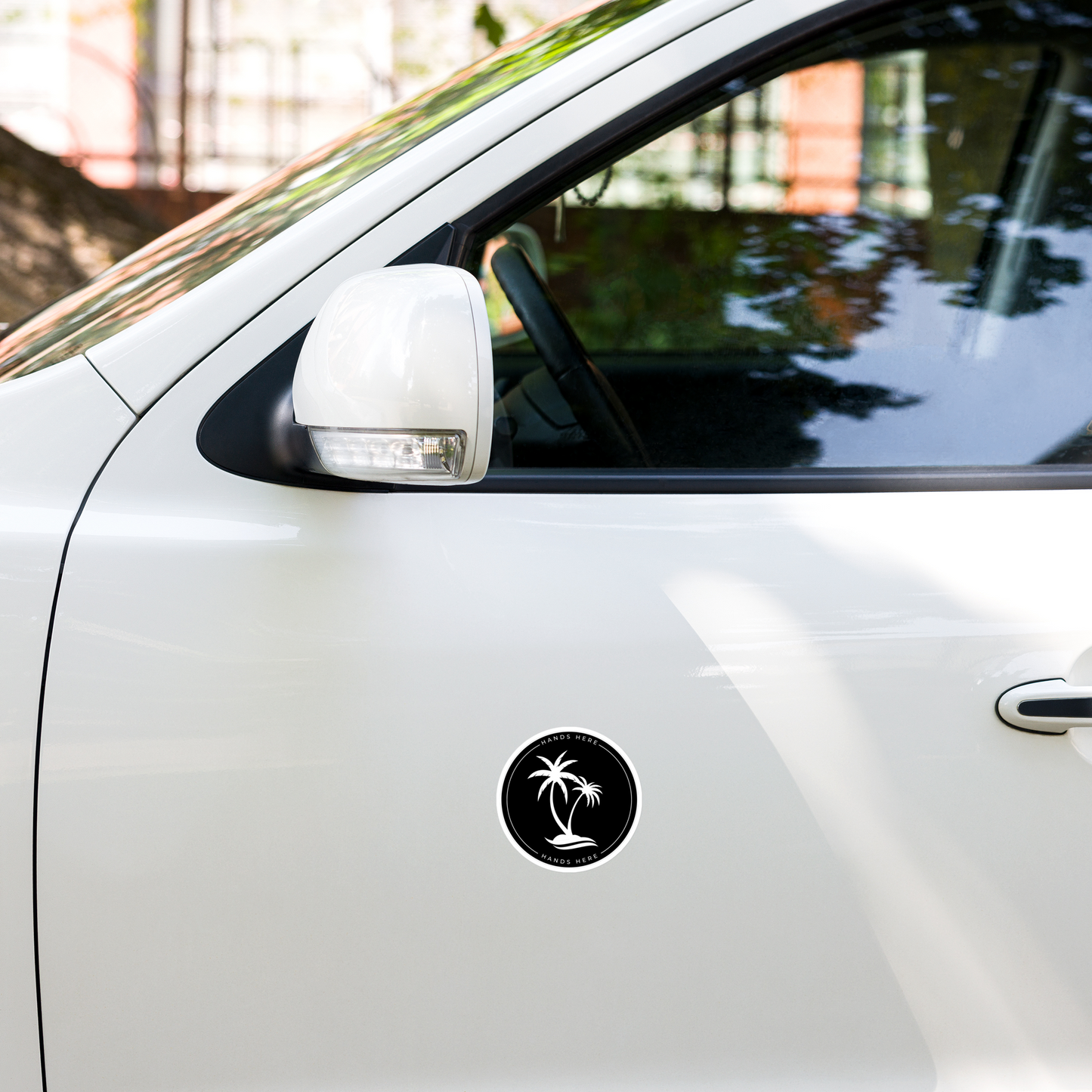 Black Hands Here Palm decal or magnet design on door panel of white car showing placement on vehicle