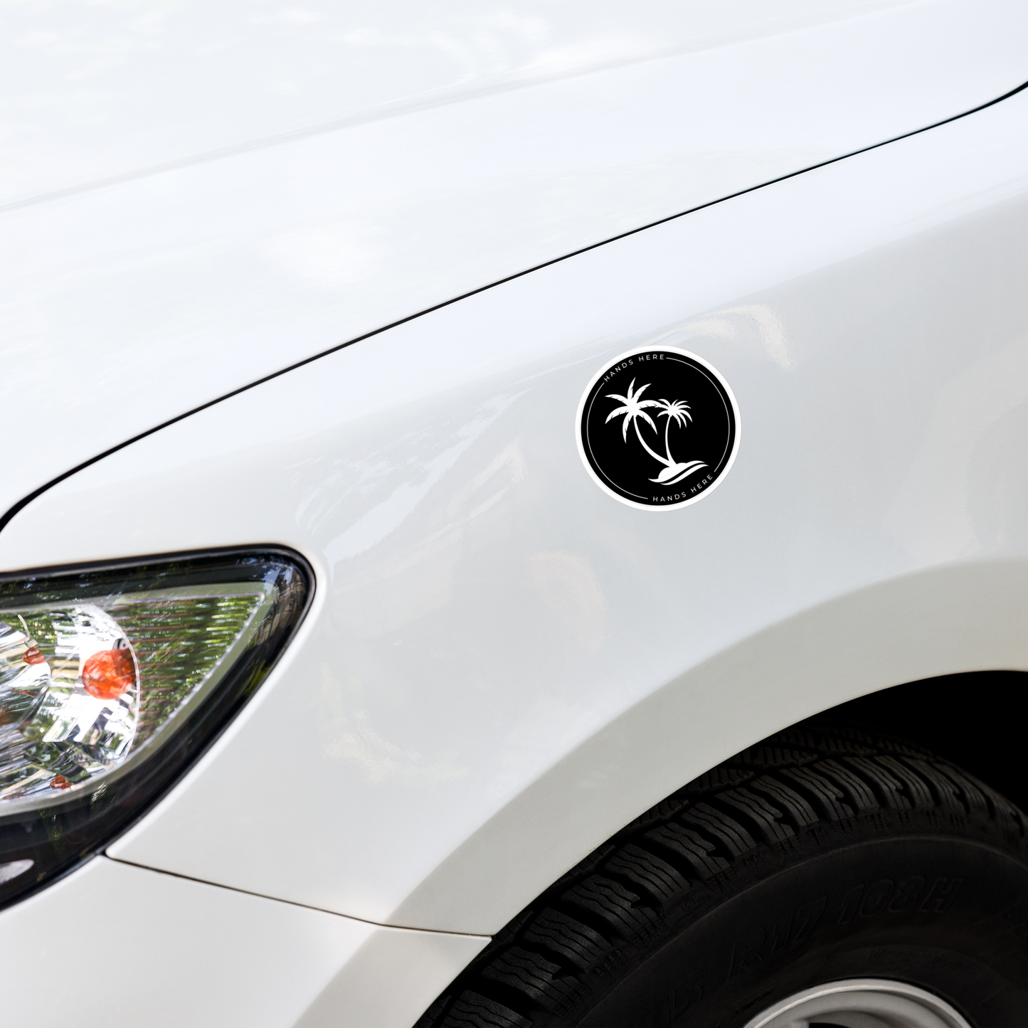 Black Hands Here Palm decal or magnet design on front panel of white car showing placement on vehicle