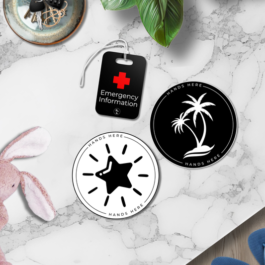 Bundle image of the Complete Safety Essentials pack showing a Tag, Decal and Magnet on a table among everyday family items like keys and toys.