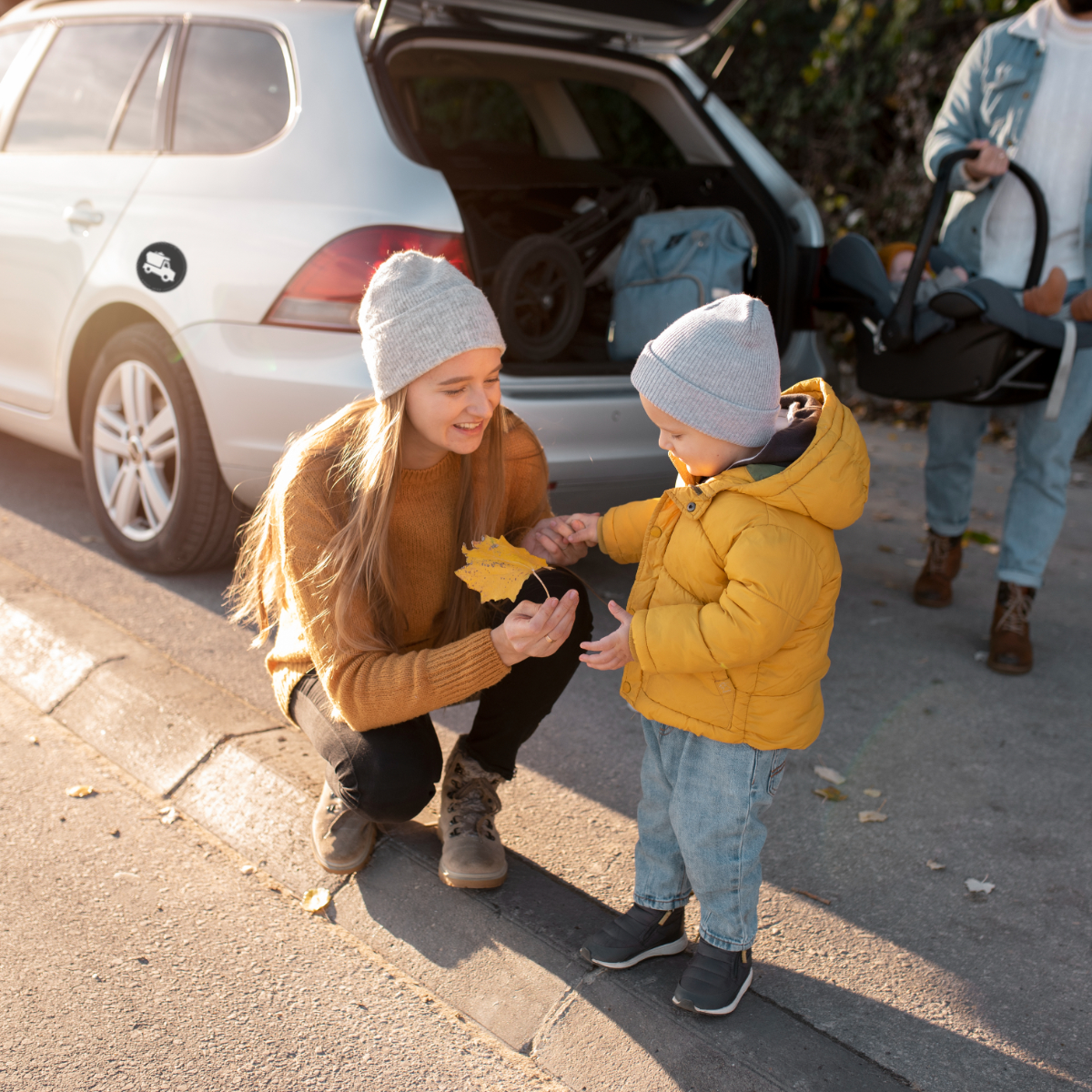 Parents and children unloading their car after everyday outing showing Hands Here decal