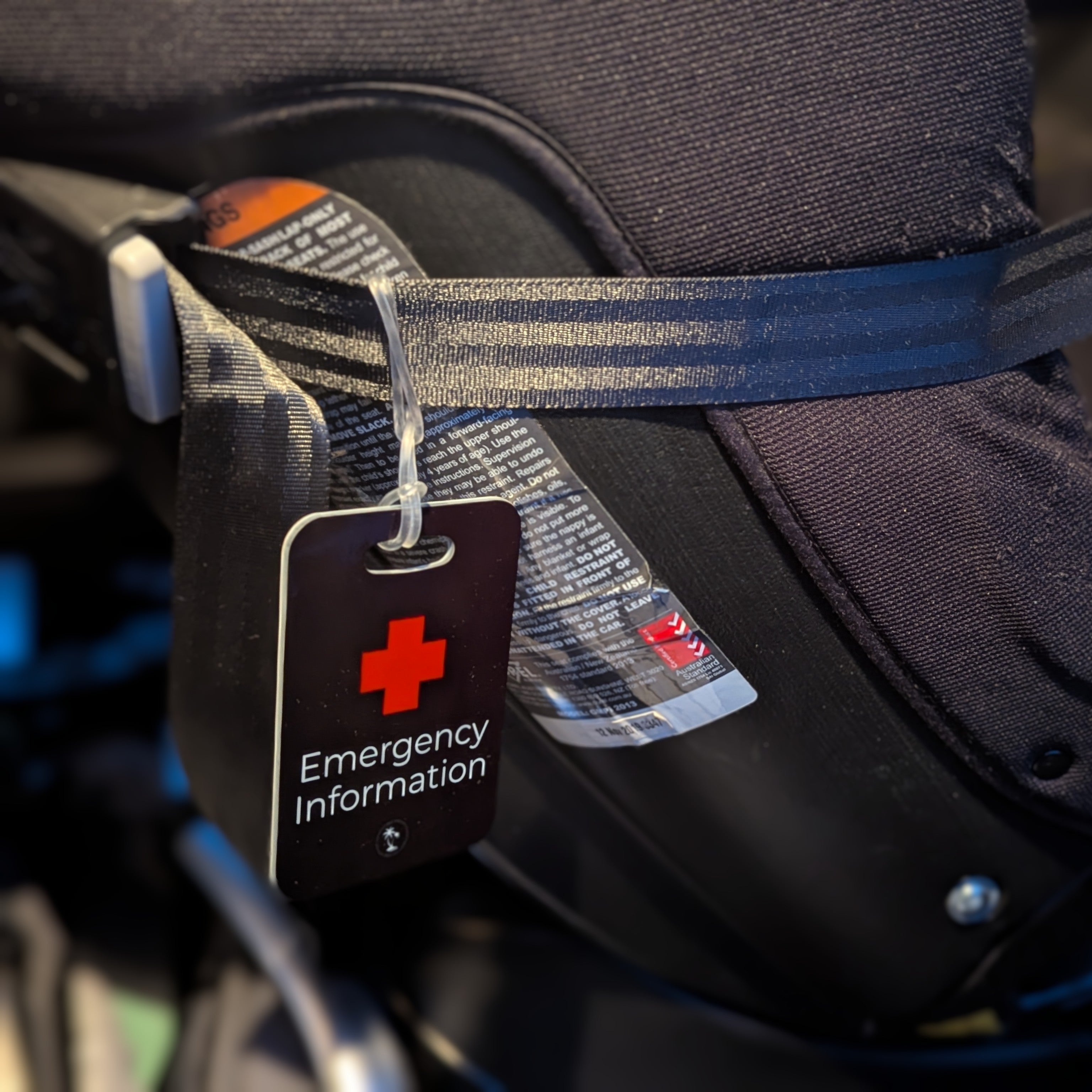 Black Hands Here Emergency Information Tag securely attached to child car seat