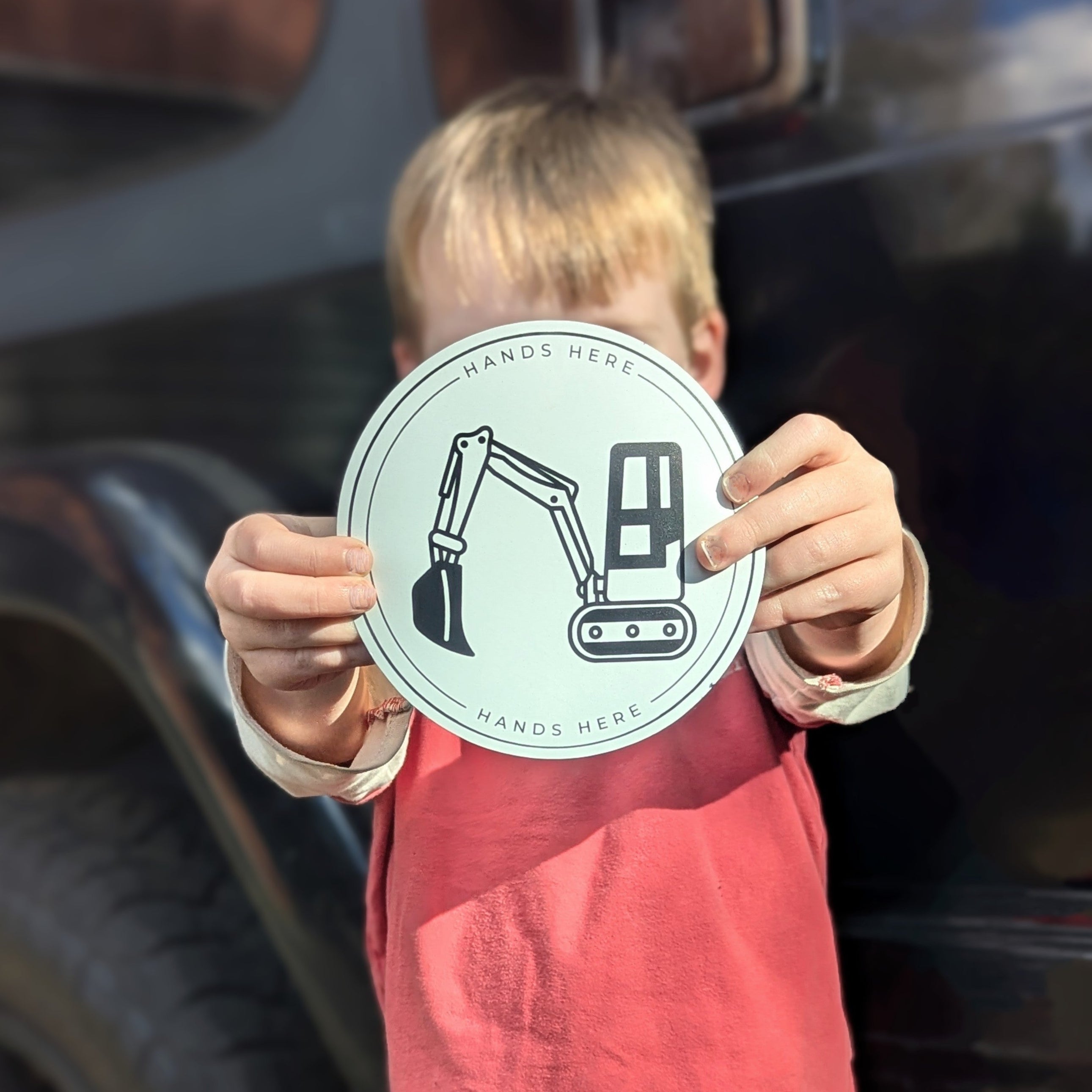 Colour image of child holding Hands Here Digger Magnet or decal design in white near car